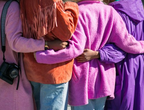 four person holding each others waist at daytime